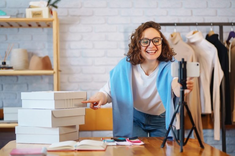 Female warehouse worker, seller, dropshipping small business owner recording new content for vlog.