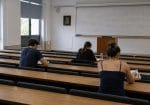 Ελάχιστοι φοιτητές σε άδειο πανεπιστημιακό αμφιθέατρο με μαθηματικές εξισώσεις στον πίνακα.